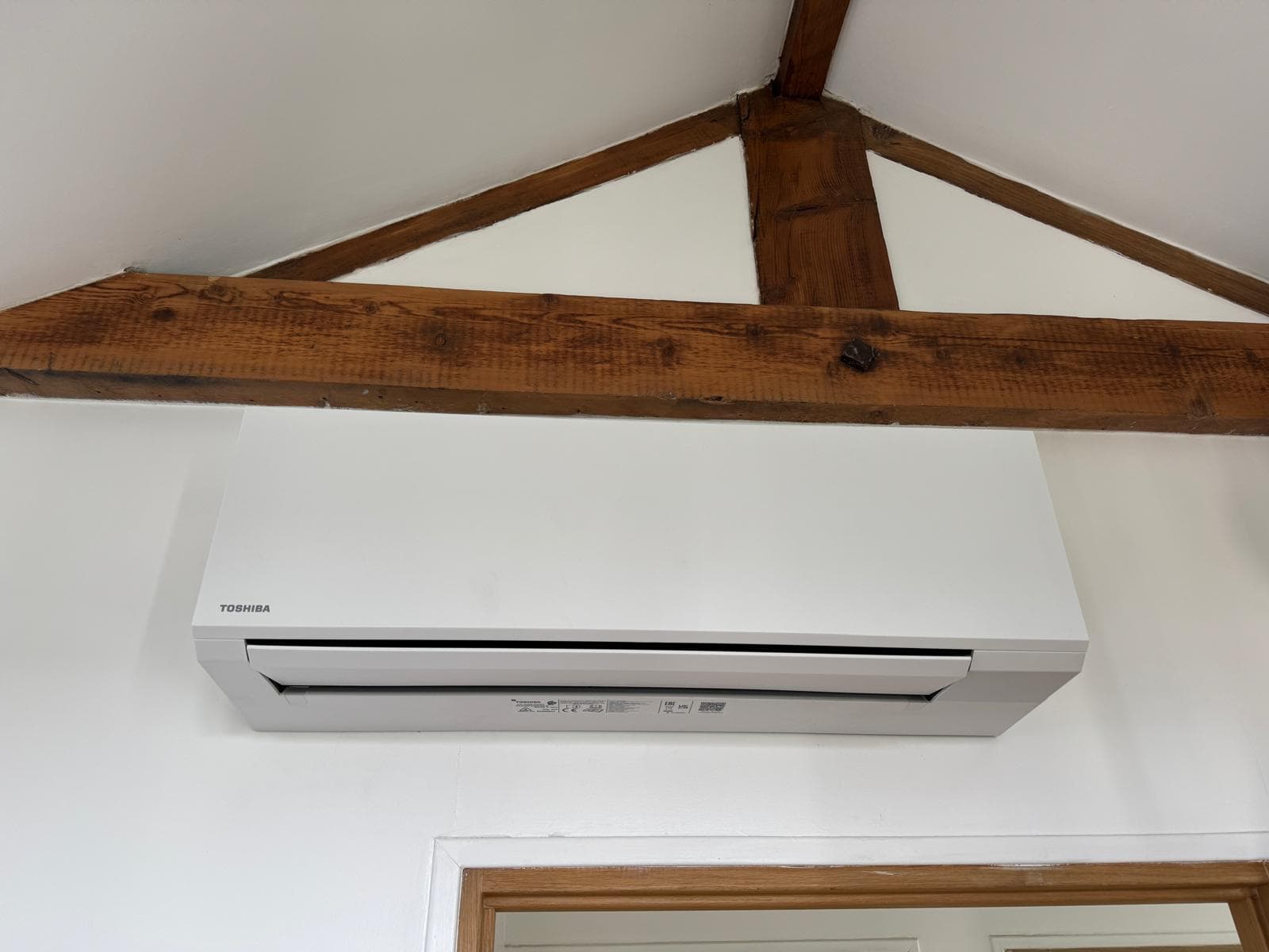 Unité intérieure Toshiba installée dans maison avec poutres apparentes
