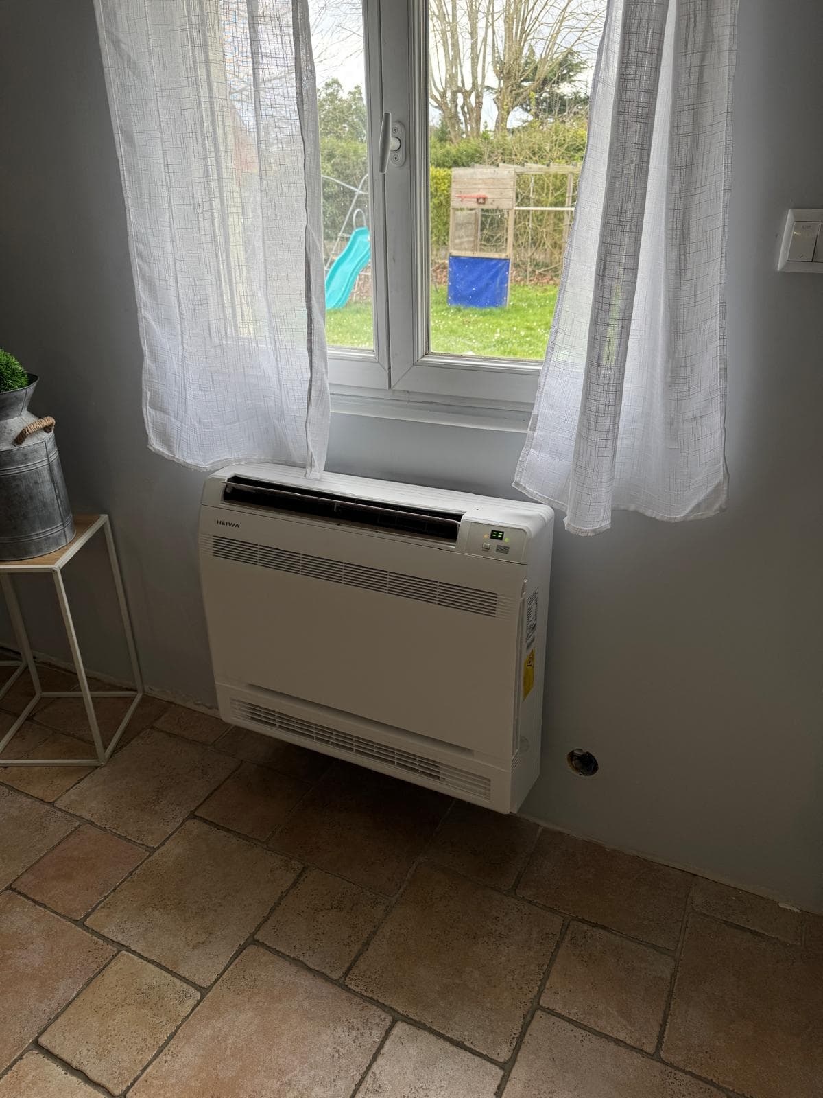 Console basse Hitachi devant fenêtre jardin